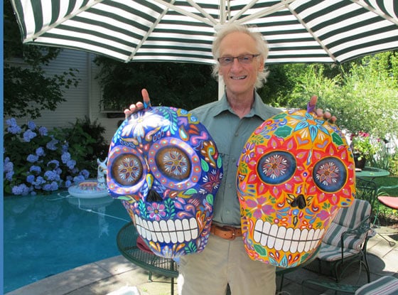 Phil Saviano holding 2 paper maché skull masks